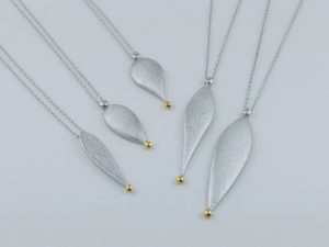 しずく型の形を逆さにして下に向かって絞るように。その先には金粒。「どんな洋服にも合わせやすい。」ことをイメージして作りました。