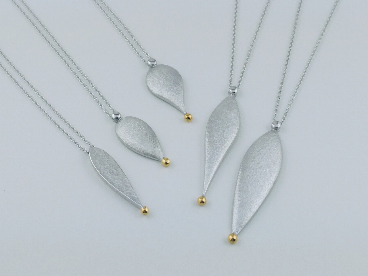 しずく型の形を逆さにして下に向かって絞るように。その先には金粒。「どんな洋服にも合わせやすい。」ことをイメージして作りました。