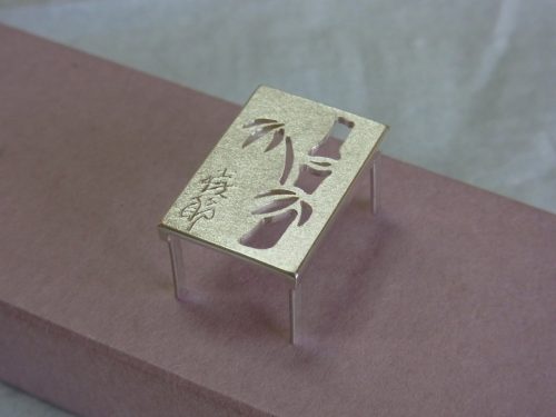竹工房・喜節のセカンドバッグの金具 素材：銀 京都の竹工房・喜節さんからご依頼を受けて製作した金具です。 竹の図案を透かし彫り、 表面はオリジナルの艶消し仕上げを施し、 「喜節」の文字をタガネで和彫りしています。