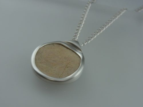 化石のネックレス 素材：Silver,化石 お預かりした化石をご希望に沿うカタチで留めました。 本体に直接チェーンを通せるようにしています。 金剛砂による艶消し仕上げ。 京都府のお客様