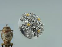 空女華薩摩作品の取っ手 素材：銀、純金 伝統工芸士・空女さんからのご依頼で制作させていただきました。 「花ずくし」とばかりに菊、百合、蕾、等々を作りながら配置を考えて製作しました。 純金粒は艶消し仕上げ。色味が濃く見えて、金の明るさが映えます。 この取っ手を付けた空女さんの作品は炎陶芸N0.130 46ページに掲載されています。 オーダーメイド 京都府